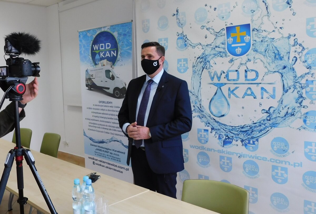 Na zdjęciu Prezydent Miasta Skierniewice Krzysztof Jażdżyk udzielający wywiadu, w tle roll up z niebieskim logo Wod-kan i kamerowozem