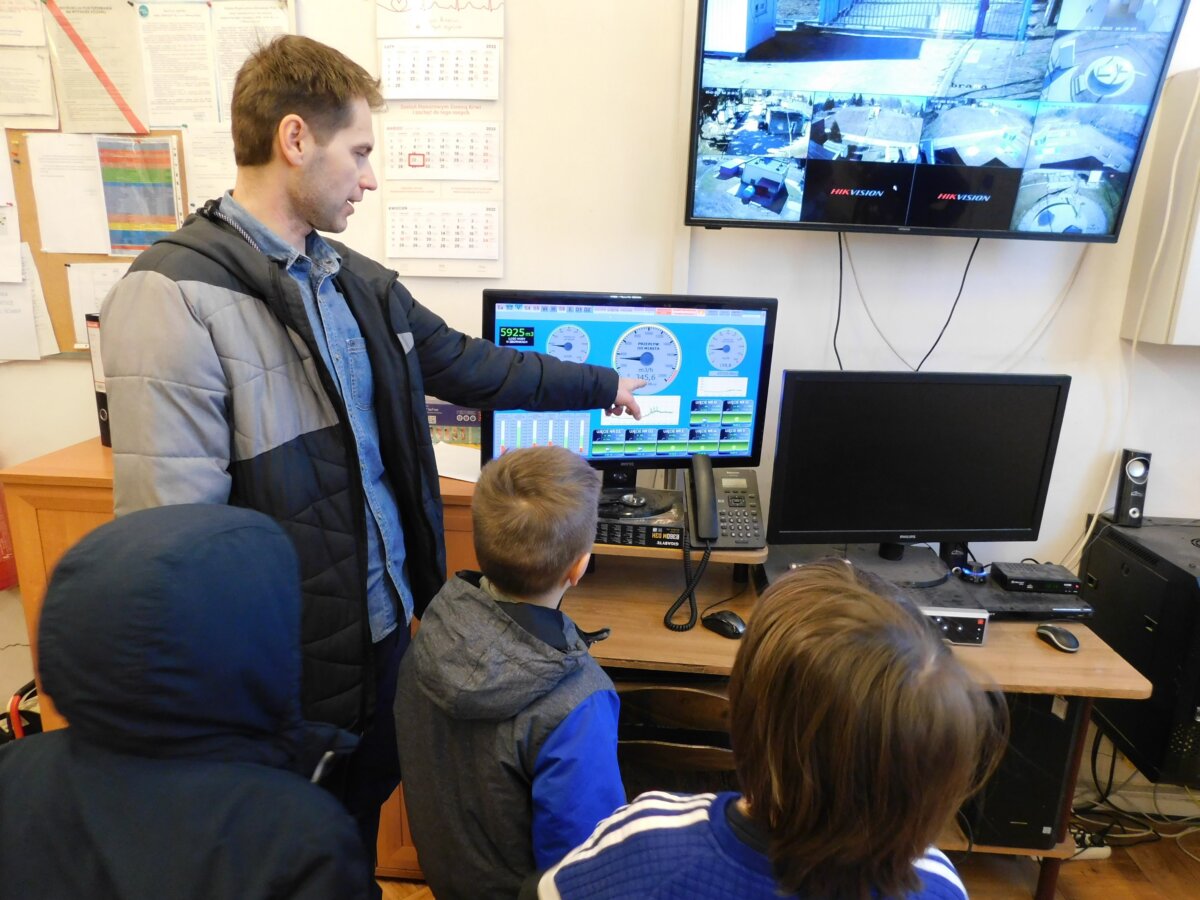 Na zdjeciu P.O Kierownika Mariusz Maszkowski pokazujący dzieciom na ekran informacje na temat stanu wody